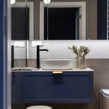 Mirrored cabinet fronts optically enlarge the bathroom space