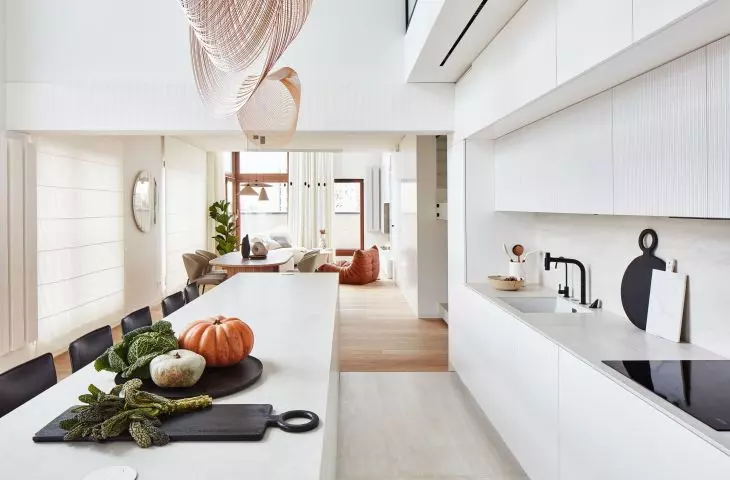 Above the long kitchen island hang sculptural lamps