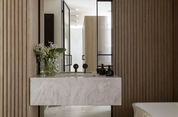 The stone washbasin relates in design to the tiles on the wall