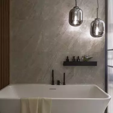 The glass-enclosed bathroom features a freestanding bathtub