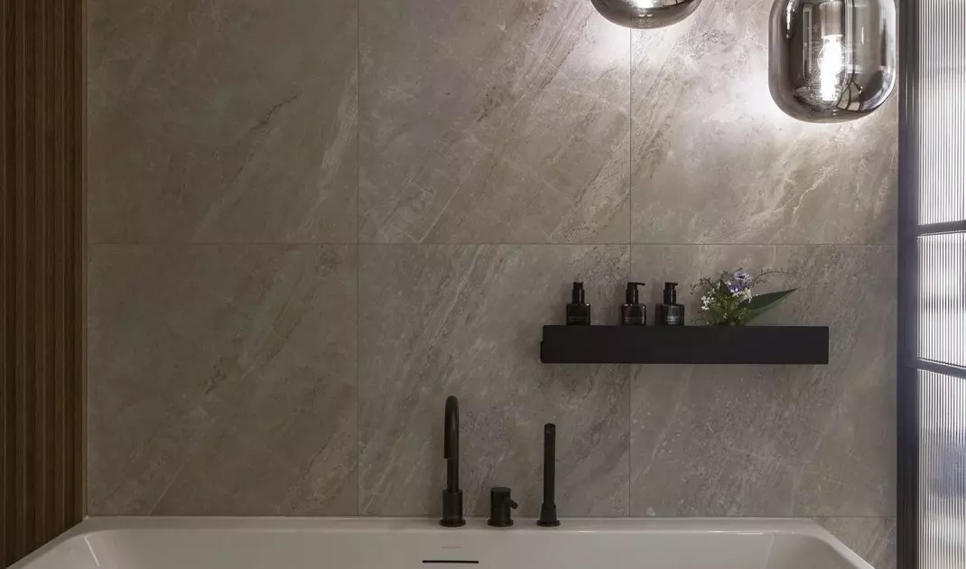 The glass-enclosed bathroom features a freestanding bathtub