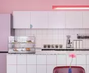 An Italian espresso machine and a display case of sweets stand on the bar