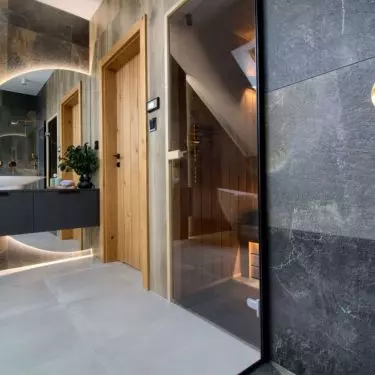 Behind the washbasin is a large illuminated mirror