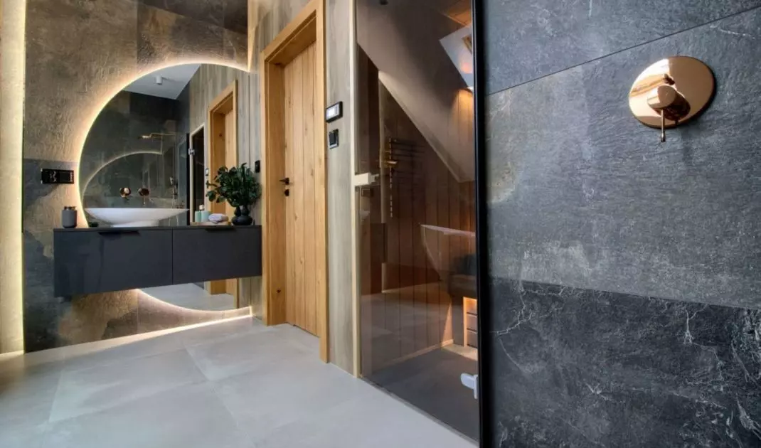 Behind the washbasin is a large illuminated mirror