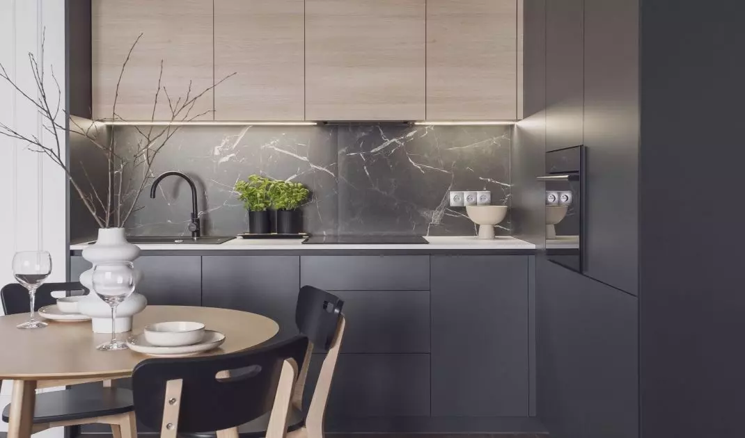 Dark kitchen flows seamlessly into dining room 