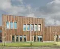 the rhythm of the wooden planks on the facade is broken by irregularly placed windows of different shapes and sizes