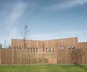 The fence refers to the wooden facade of the kindergarten