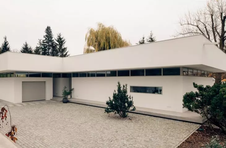 high, projecting beyond the line of the facade, the massive attic wall obscures the sloping roof of the house