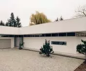 high, projecting beyond the line of the facade, the massive attic wall obscures the sloping roof of the house