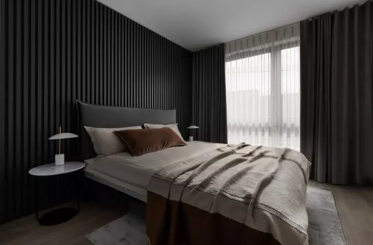 The bedroom has a fluted wall 