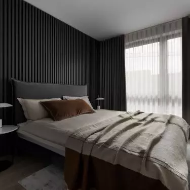 The bedroom has a fluted wall 