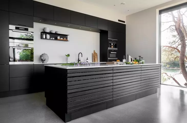 The kitchen is kept in dark colors