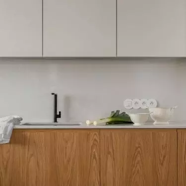 The upper beige cabinets were juxtaposed with the veneer at the bottom of the development
