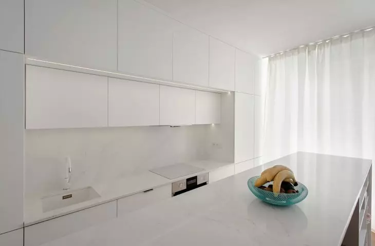 The kitchen is dominated by white