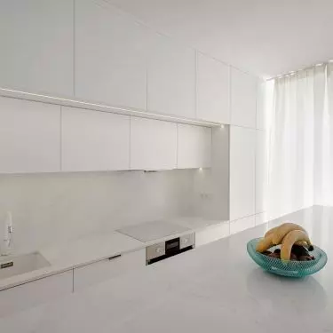 The kitchen is dominated by white