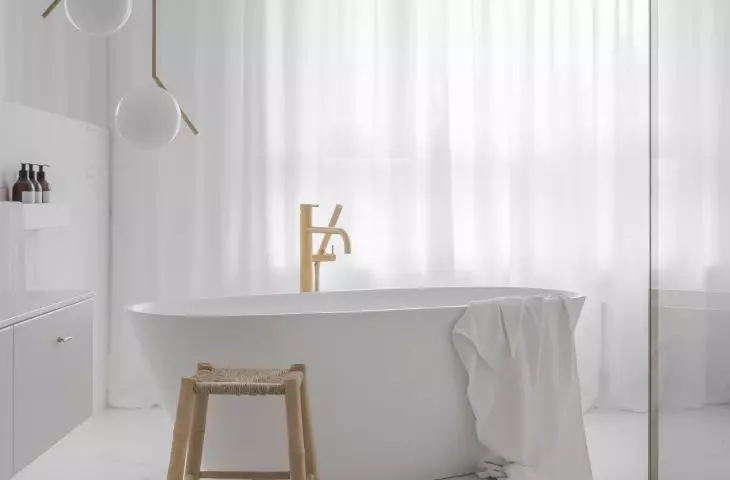 The free-standing bathtub is complemented by a gold faucet
