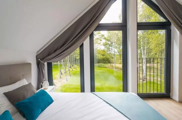 Large glazing in the bedroom provides a beautiful view of the surrounding nature