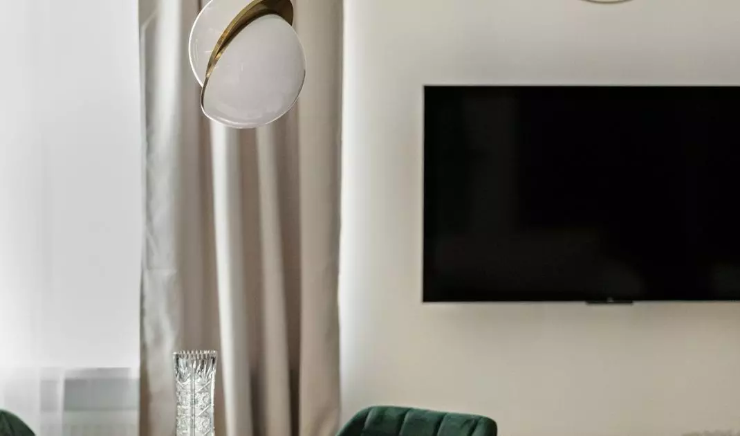 The dining room is formed by a round table and upholstered chairs in a shade of green