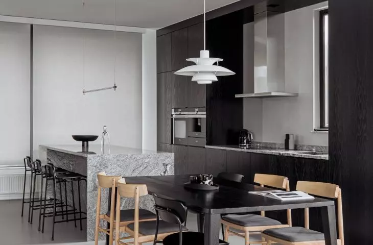 Black dining table continues the layout of the kitchen island