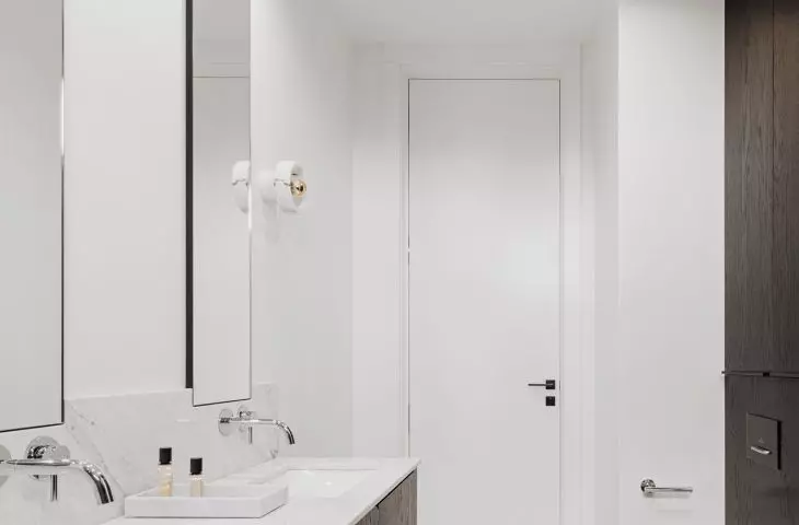 A narrow bathroom is optically shortened by the contrast of white and black 