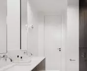 A narrow bathroom is optically shortened by the contrast of white and black 