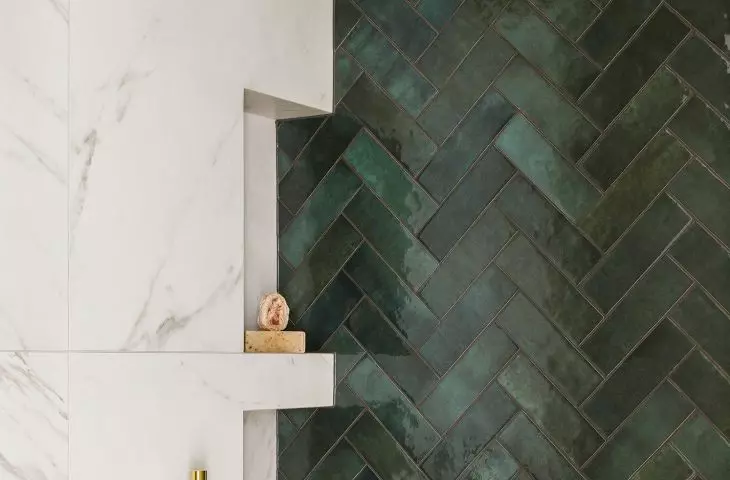 In the shower you will find green tiles arranged in a herringbone pattern