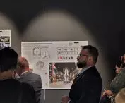 Marcin Wojczyński z Trias AVI na tle plansz ze zwycięskim projektem