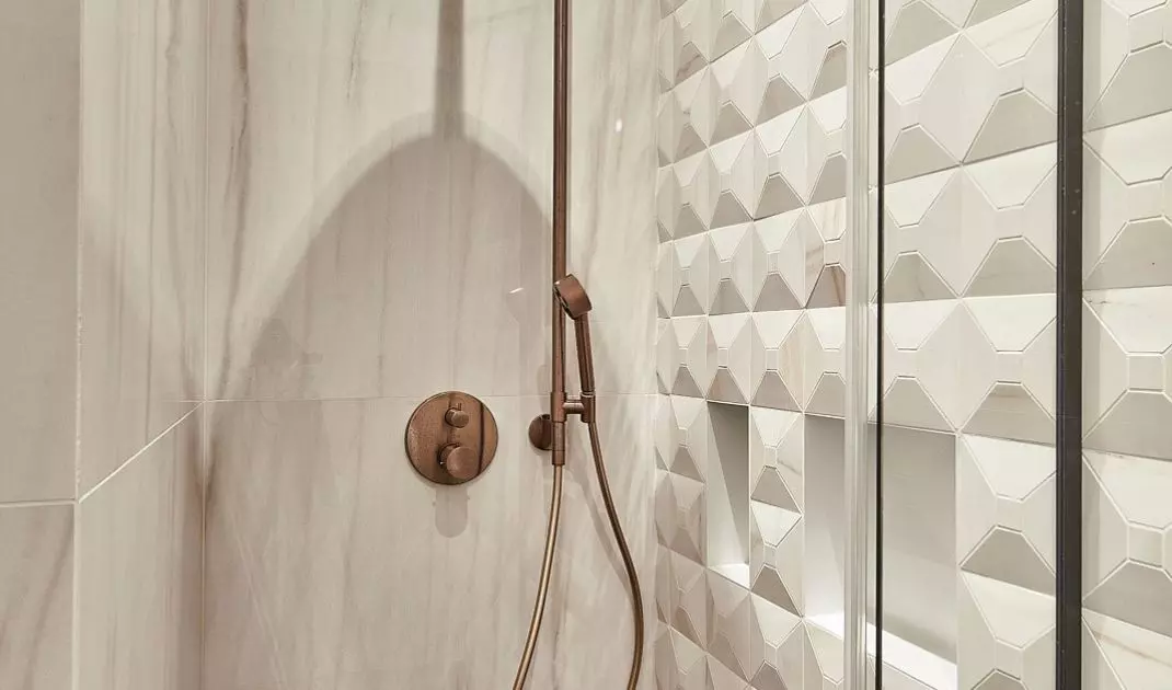 The wall of the shower was lined with three-dimensional tiles