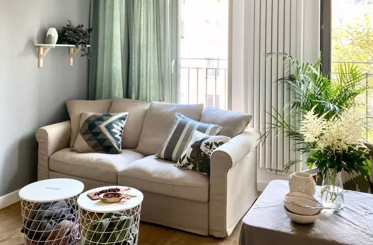 Simple sofa and modern coffee tables combine with minimalist kitchen