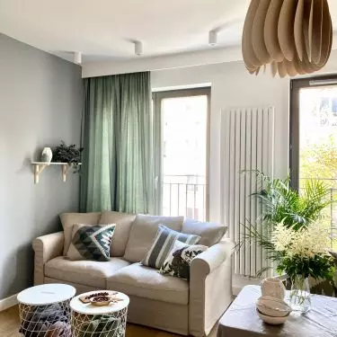 Simple sofa and modern coffee tables combine with minimalist kitchen
