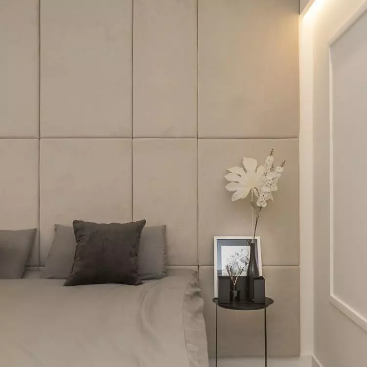 The wall behind the bed was decorated with upholstered panels