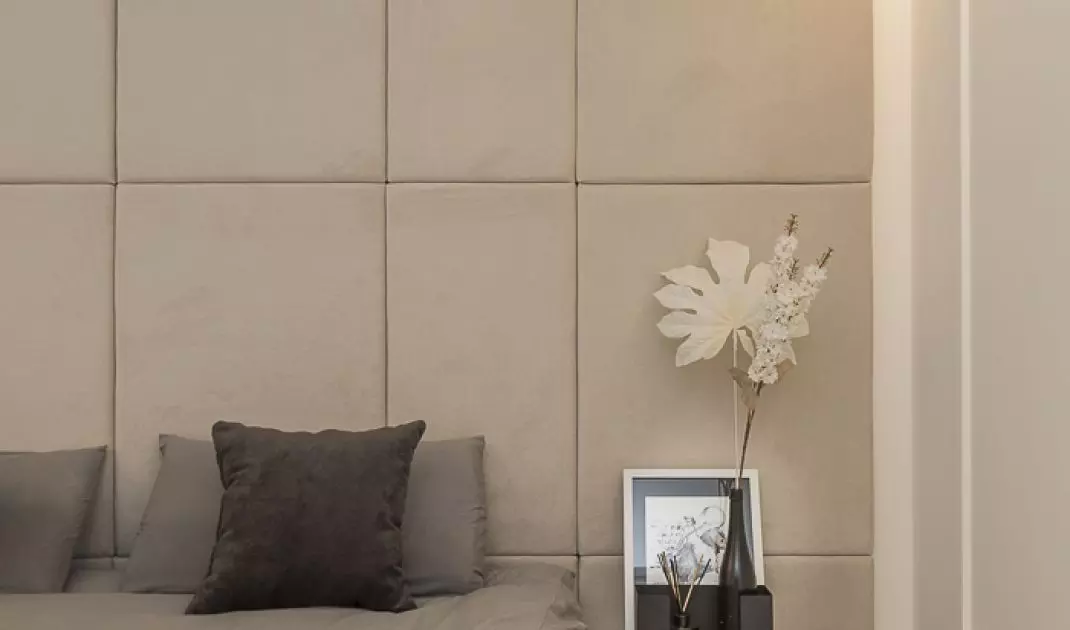 The wall behind the bed was decorated with upholstered panels