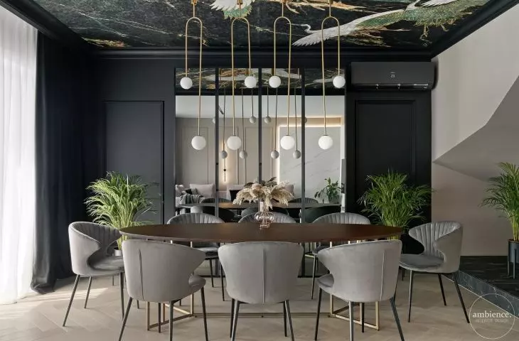 An oval large table and gray upholstered chairs make up the dining area