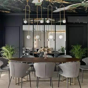 An oval large table and gray upholstered chairs make up the dining area
