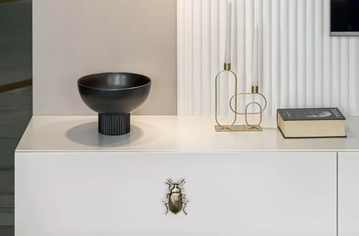 The wall with the tv is decorated with fluting