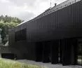 Black facade cladding allows the block to blend in with the forest surroundings