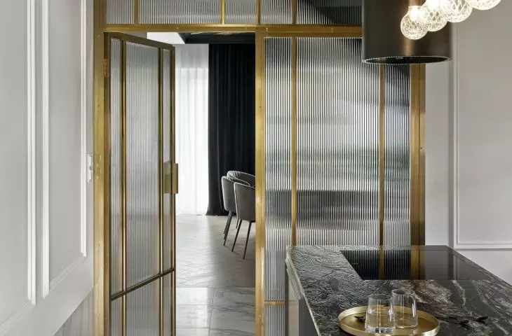 The kitchen is entered through a gold door with fluted glass