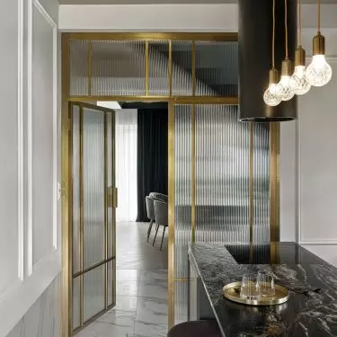 The kitchen is entered through a gold door with fluted glass