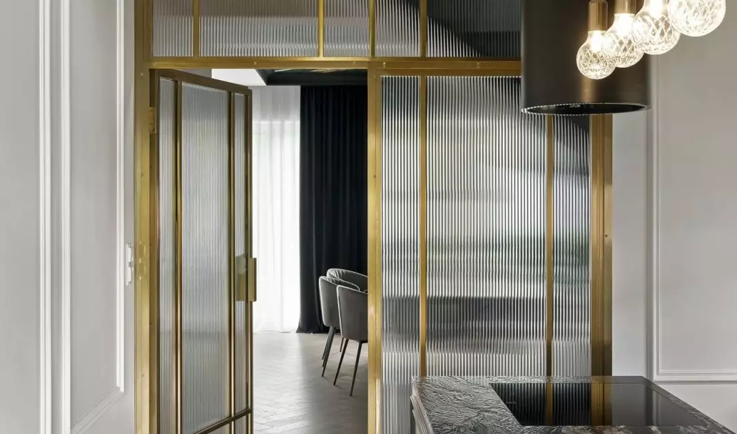 The kitchen is entered through a gold door with fluted glass