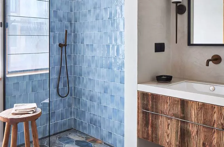 The wall in the shower was lined with shiny tiles