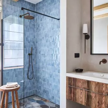 The wall in the shower was lined with shiny tiles