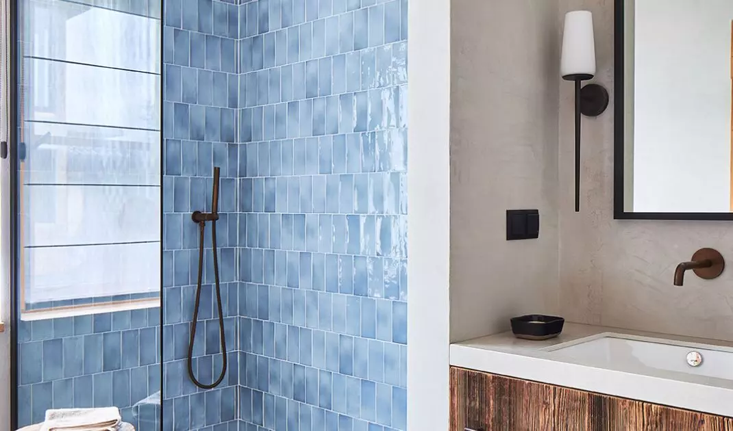 The wall in the shower was lined with shiny tiles