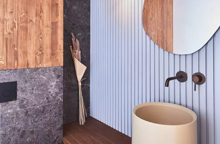 The guest toilet is distinguished by a fluted blue wall and a large sink