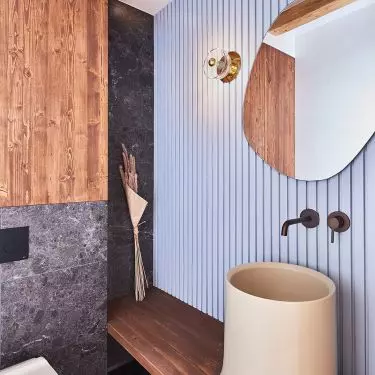 The guest toilet is distinguished by a fluted blue wall and a large sink