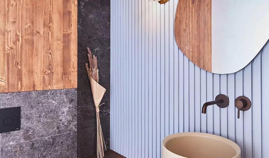 The guest toilet is distinguished by a fluted blue wall and a large sink