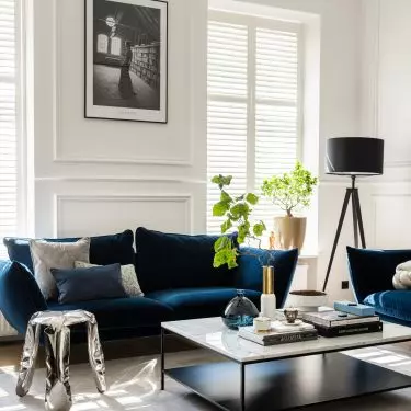  The only color accent is the sofas upholstered in soft navy blue velvet