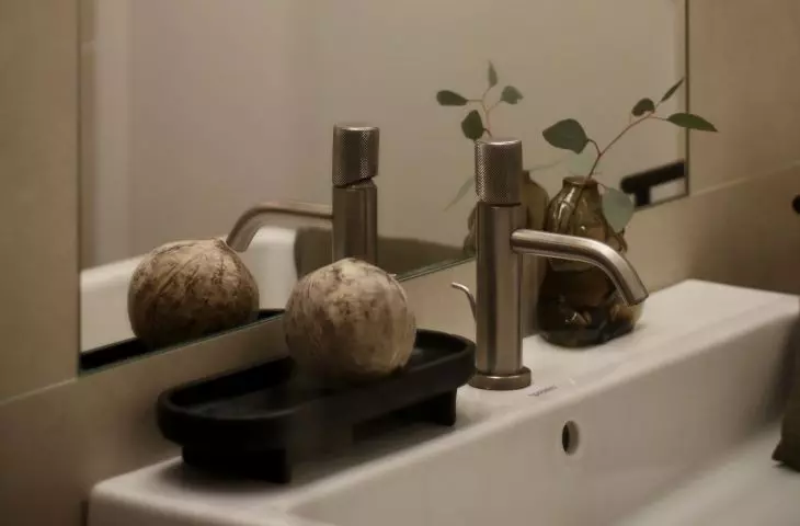 The bathroom arrangement is complemented by a large illuminated mirror