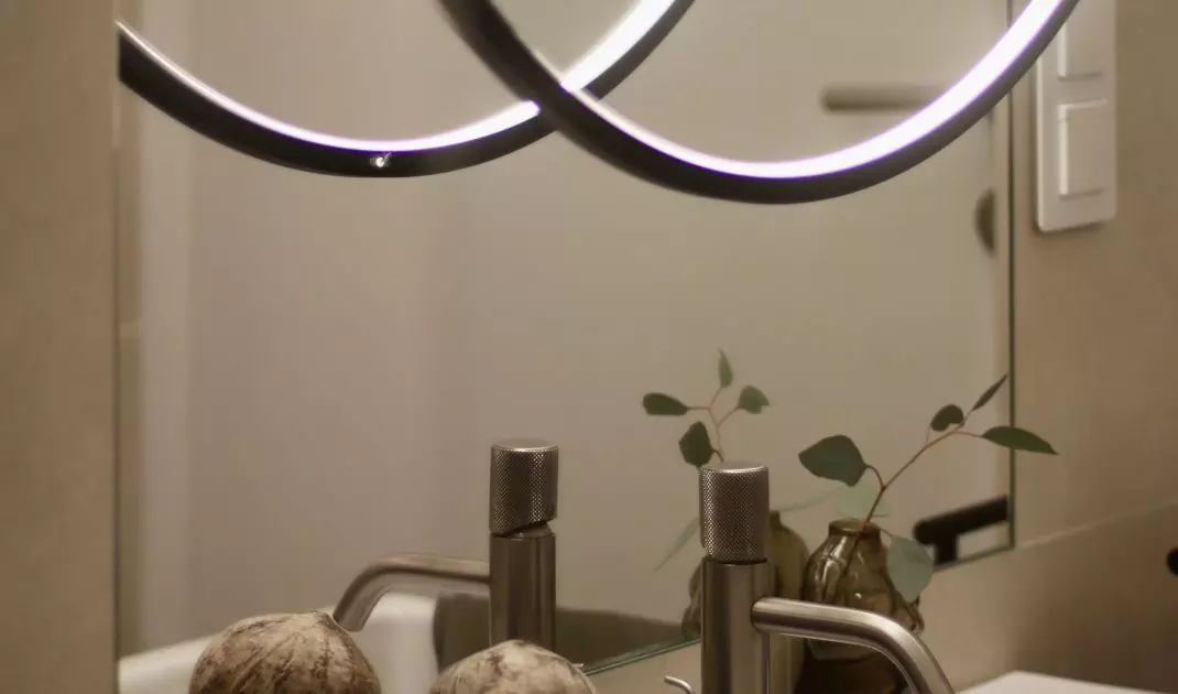 Aranżację łazienki uzupełnia duże podświetlane lustro