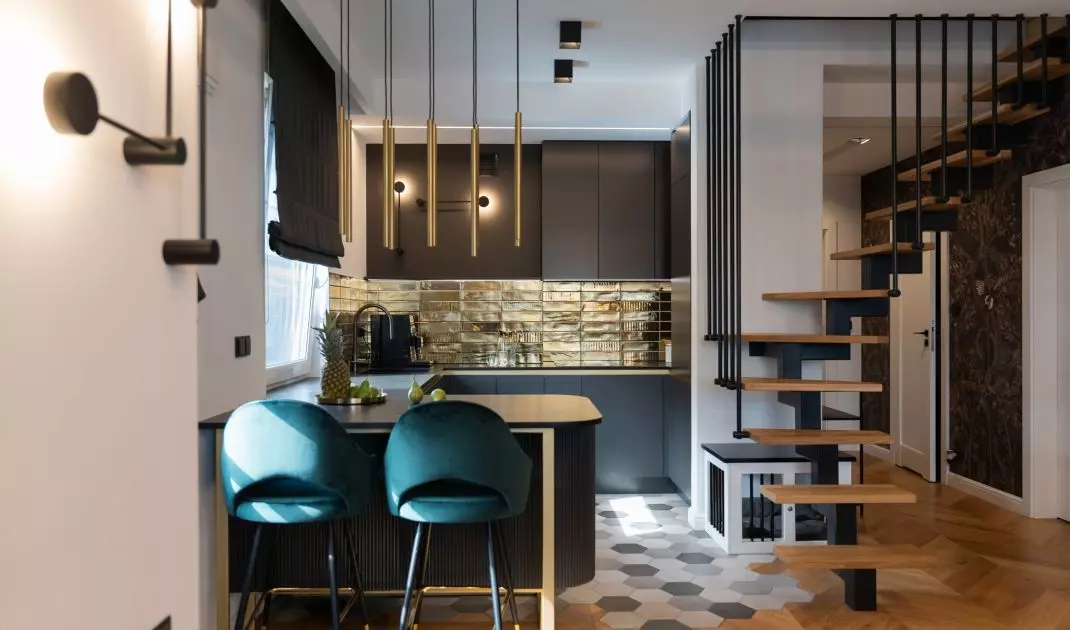 The wall above the countertop has been tiled with irregularly textured gold tiles