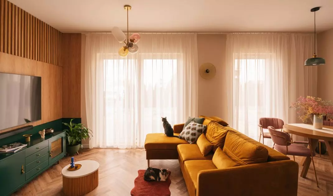 Mustard sofa connects the living room area with the kitchen